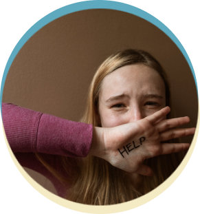 Woman with "HELP" written on hand covering mouth.